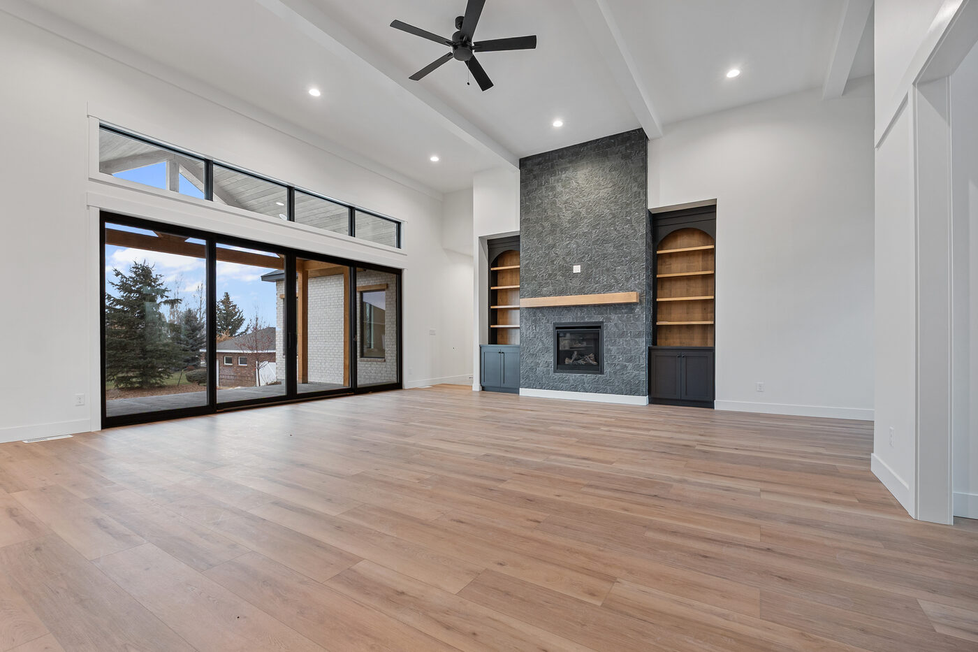 Floor-to-ceiling stone gas fireplace with built-in shelving — Rexburg home for sale