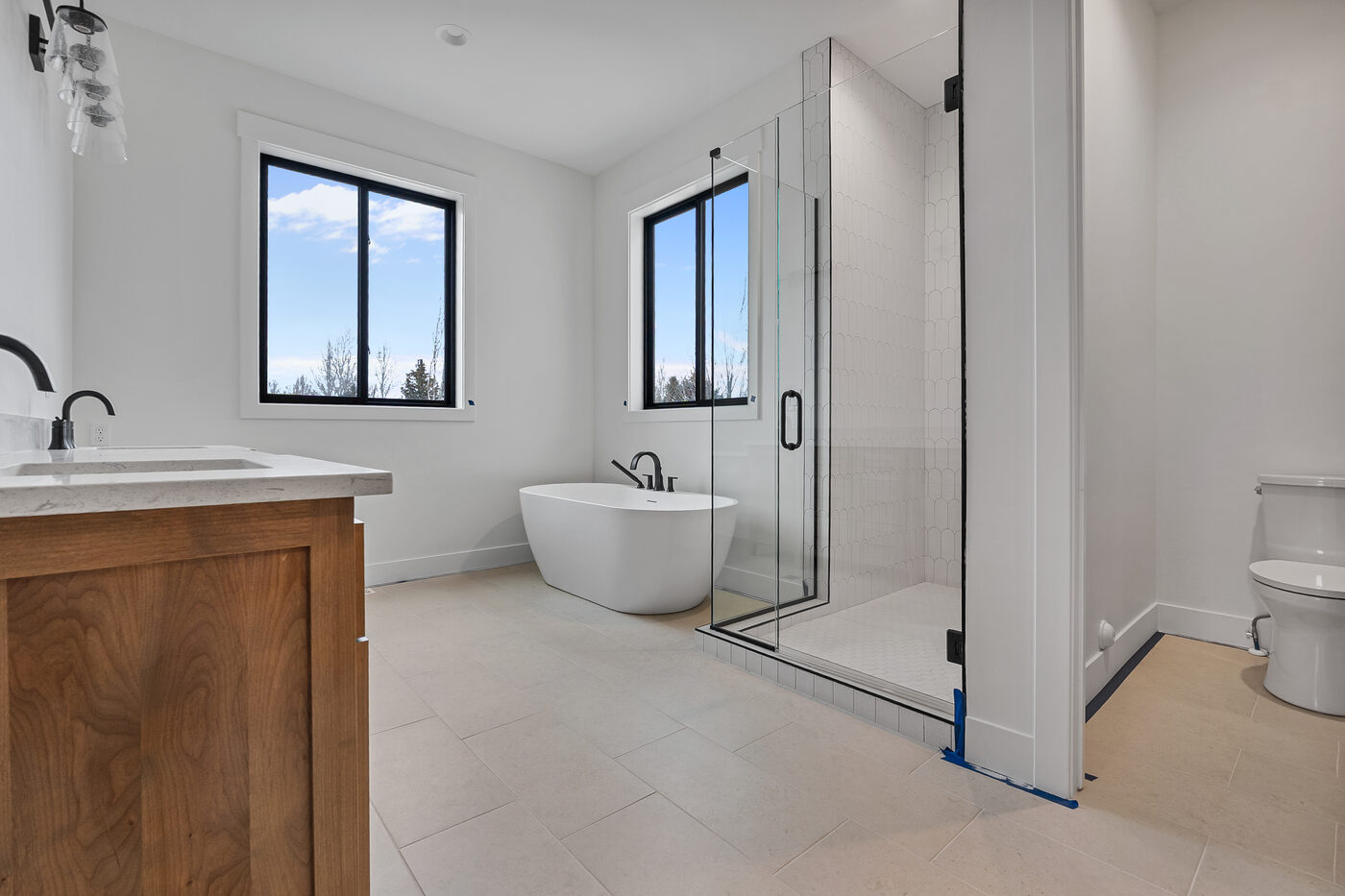 Spa-like primary bathroom with freestanding soaking tub and glass shower enclosure